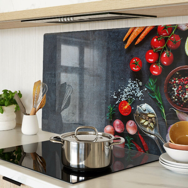 Glas-Schneidebrett mit Motiv von Gemüse und Gewürzen auf dunklem Hintergrund