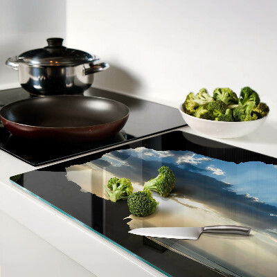 Glas-Schneidebrett mit Motiv eines Sonnenuntergangs hinter Wolken