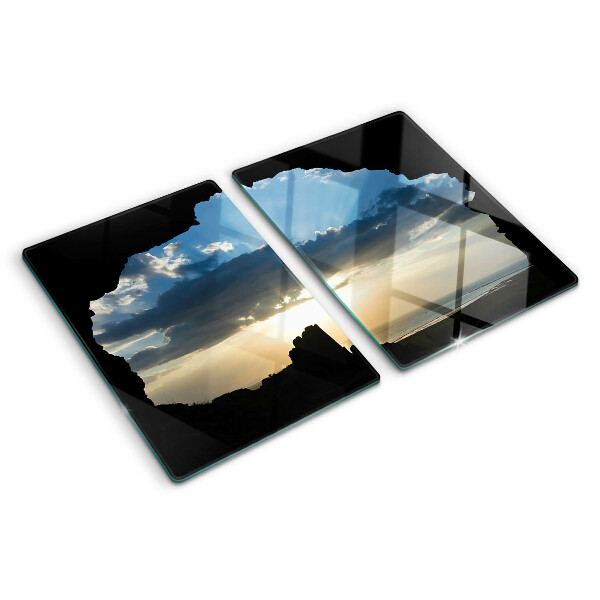 Glas-Schneidebrett mit Motiv eines Sonnenuntergangs hinter Wolken