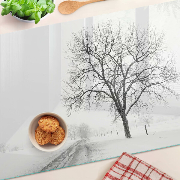 Schneidebrett mit Motiv einer winterlichen Landschaft und einem Baum