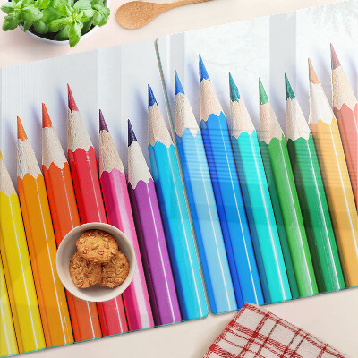 Schneidebrett Glas mit farbigen Stiften nebeneinander angeordnet