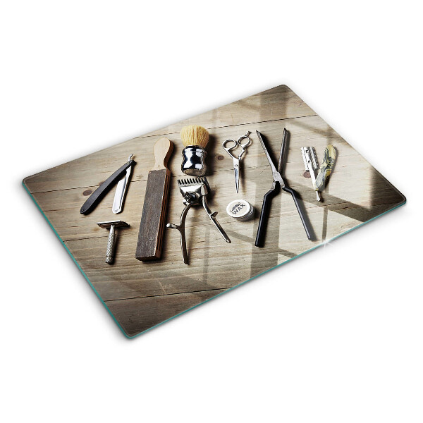 Glas-Schneidebrett mit Friseurwerkzeugen auf Holzoptik