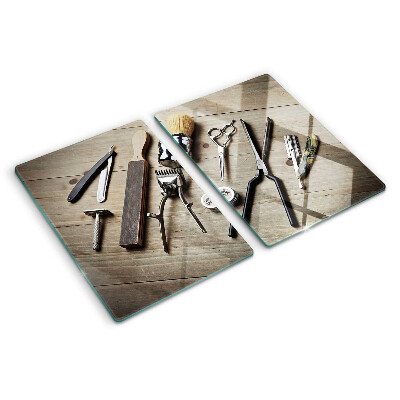 Glas-Schneidebrett mit Friseurwerkzeugen auf Holzoptik