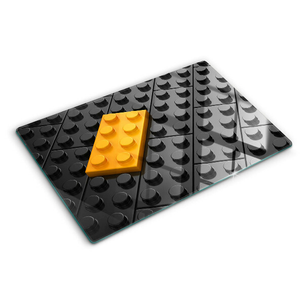 Glas-Schneidebrett mit Motiv aus LEGO-Steinen auf schwarzem Hintergrund