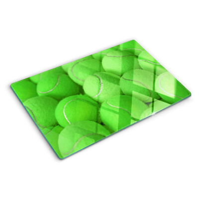 Schneidebrett mit Motiv von Tennisbällen auf grünem Hintergrund