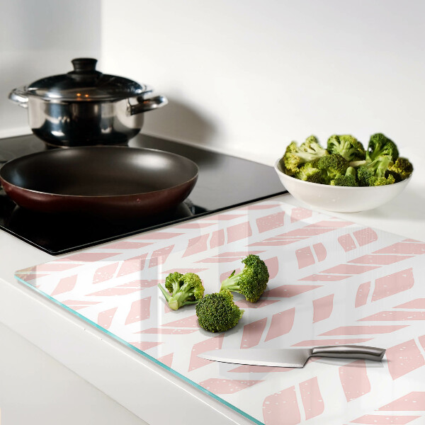 Glas-Schneidebrett mit Blättern in rosafarbenem Ton