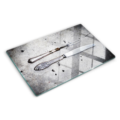 Schneidebrett mit Besteckmotiv auf Betongrund