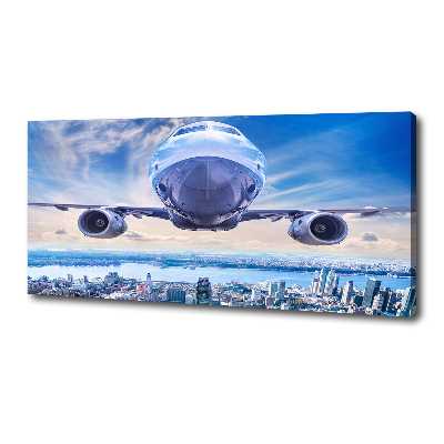Bild auf leinwand Ein Flugzeug über der Stadt