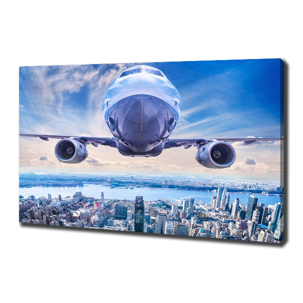 Bild auf leinwand Ein Flugzeug über der Stadt