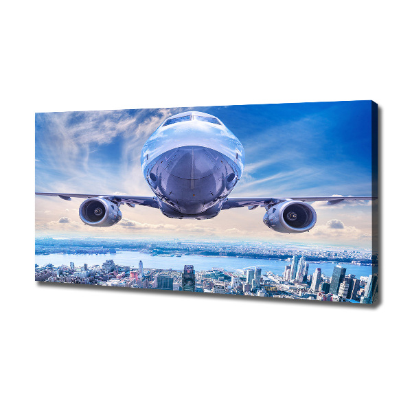 Bild auf leinwand Ein Flugzeug über der Stadt