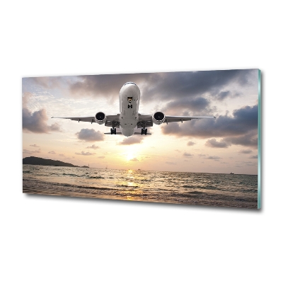 Foto glasbild Ein Flugzeug über dem Meer