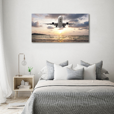 Foto glasbild Ein Flugzeug über dem Meer