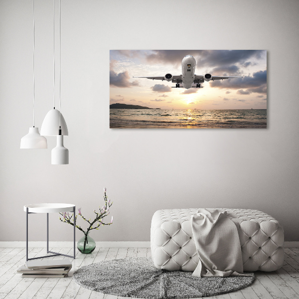 Foto glasbild Ein Flugzeug über dem Meer