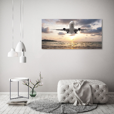 Foto glasbild Ein Flugzeug über dem Meer