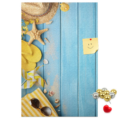 Pinnwand mit Sommeraccessoires vor blauem Holzgrund