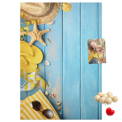 Pinnwand mit Sommeraccessoires vor blauem Holzgrund