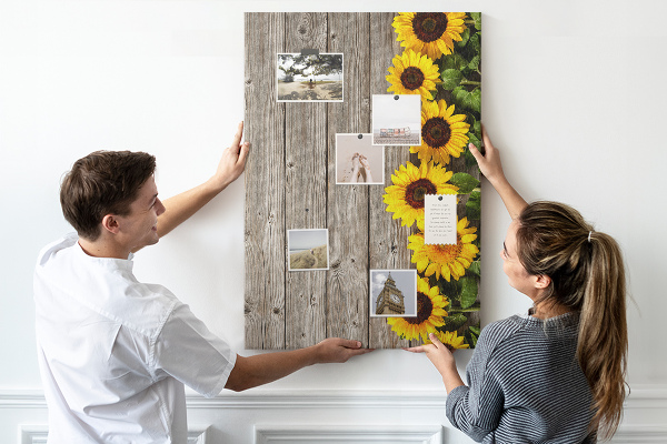 Kork-Pinnwand mit Sonnenblumen auf Holzbrett-Hintergrund