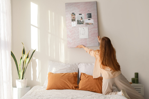 Pinnwand mit Motiv von zarten rosa Rosen im Hintergrund