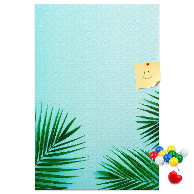 Pinnwand mit tropischen Blättern auf blauem Hintergrund