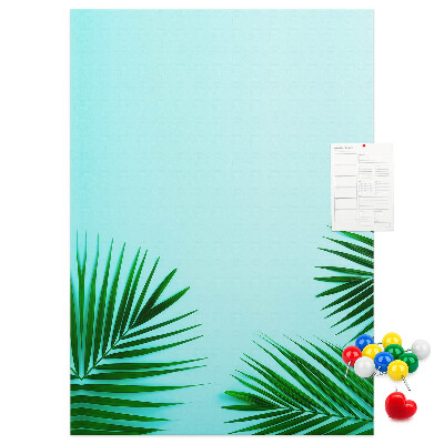 Pinnwand mit tropischen Blättern auf blauem Hintergrund