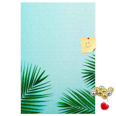 Pinnwand mit tropischen Blättern auf blauem Hintergrund