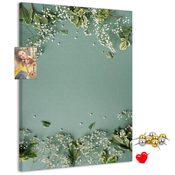 Pinnwand mit grünem Hintergrund, zarten Blüten und Blättern
