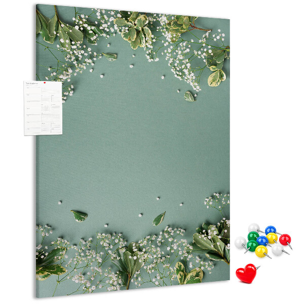 Pinnwand mit grünem Hintergrund, zarten Blüten und Blättern