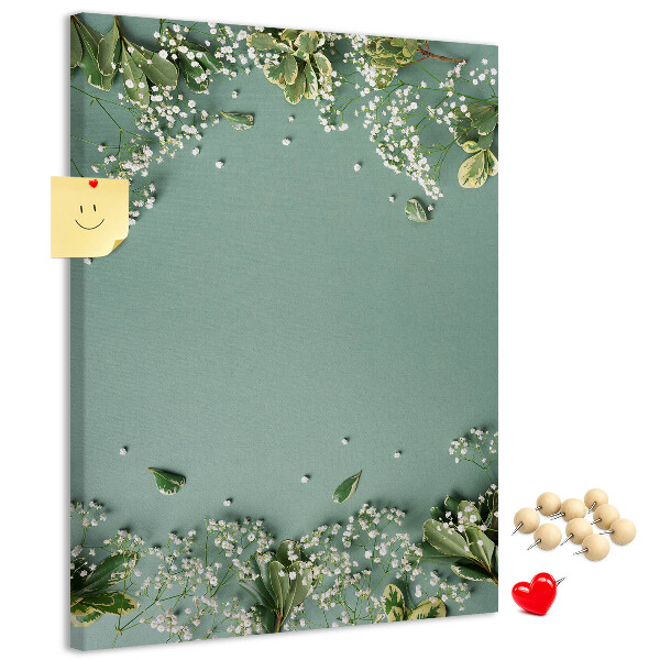 Pinnwand mit grünem Hintergrund, zarten Blüten und Blättern