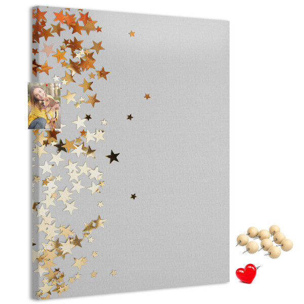 Pinnwand mit goldenen und silbernen Sternen auf grauem Grund