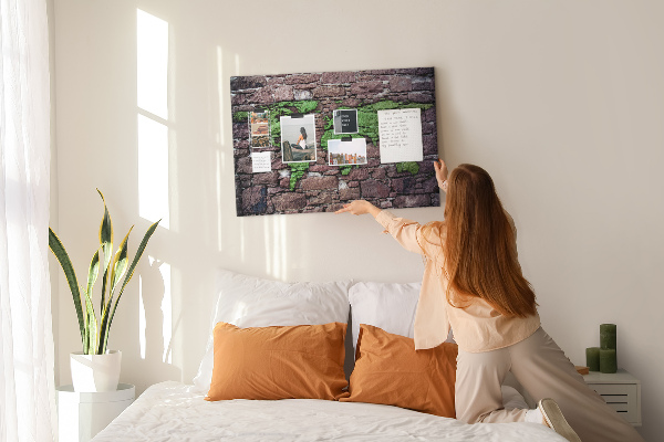 Korktafel mit Motiv einer grünen Weltkarte auf einer Steinmauer