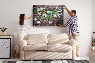 Korktafel mit Motiv einer grünen Weltkarte auf einer Steinmauer