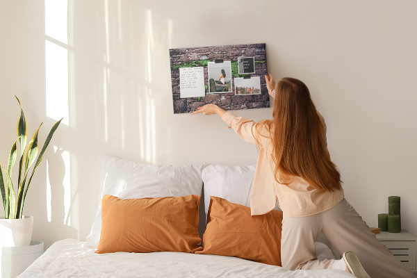 Korktafel mit Motiv einer grünen Weltkarte auf einer Steinmauer