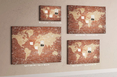 Korktafel mit Weltkartenmotiv vor einer Backsteinmauer