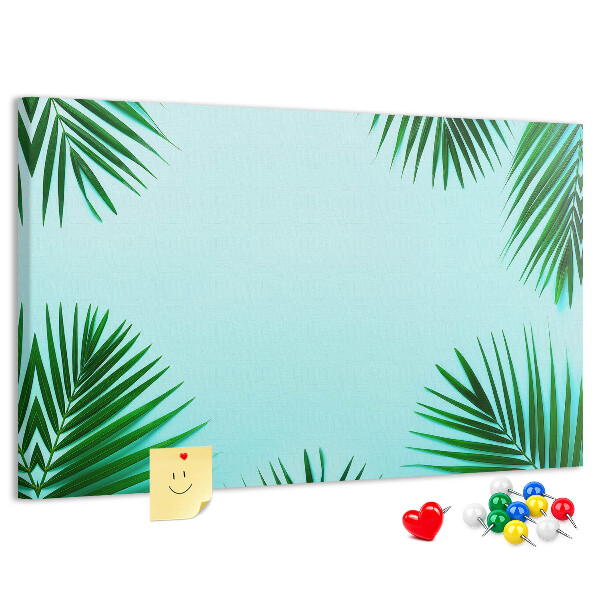 Korktafel mit tropischen Blättern auf blauem Hintergrund