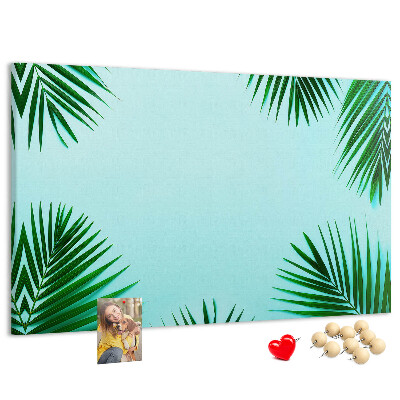 Korktafel mit tropischen Blättern auf blauem Hintergrund