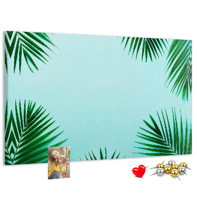 Korktafel mit tropischen Blättern auf blauem Hintergrund