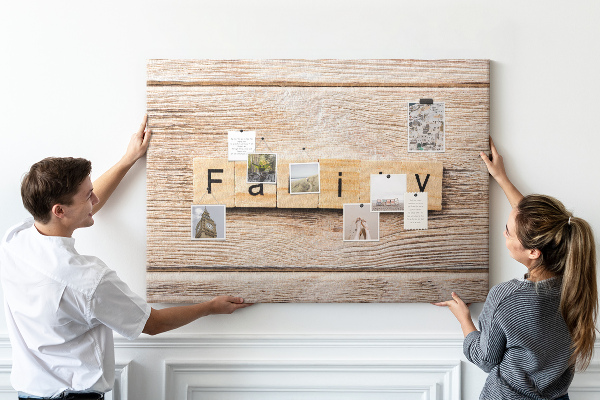 Korktafel mit Motiv einer Familie vor einem Holzbrett