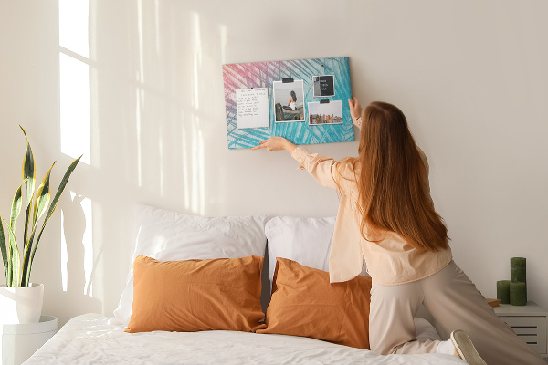 Korktafel mit Motiv tropische Blätter auf pastellfarbenem Hintergrund