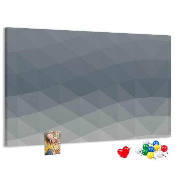 Korktafel mit geometrischen Graustufendreiecken im Hintergrund