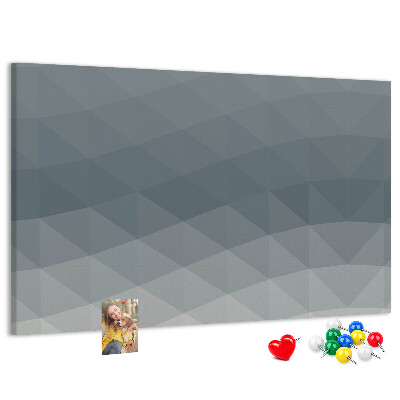 Korktafel mit geometrischen Graustufendreiecken im Hintergrund