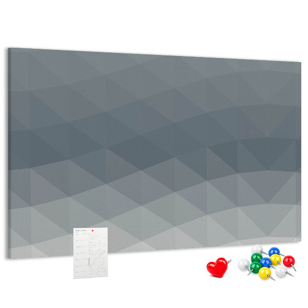Korktafel mit geometrischen Graustufendreiecken im Hintergrund