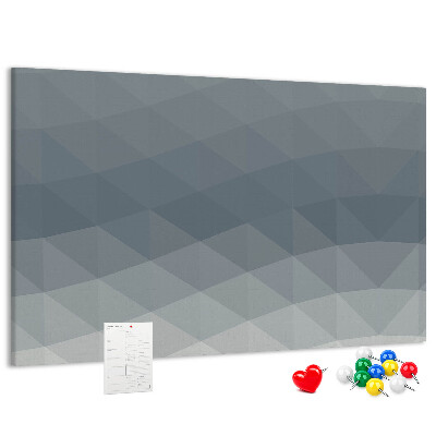 Korktafel mit geometrischen Graustufendreiecken im Hintergrund
