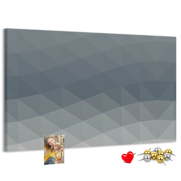 Korktafel mit geometrischen Graustufendreiecken im Hintergrund