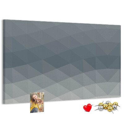 Korktafel mit geometrischen Graustufendreiecken im Hintergrund