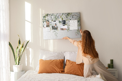 Korktafel mit Motiv aus grünen Blättern und zarten Blüten