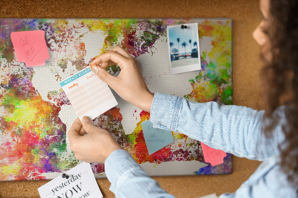 Korktafel mit farbenfroher Weltkarte im Aquarellstil