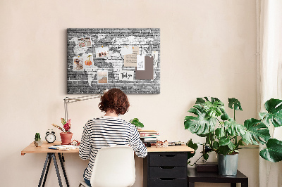 Korktafel mit Motiv Weltkarte an einer Backsteinmauer