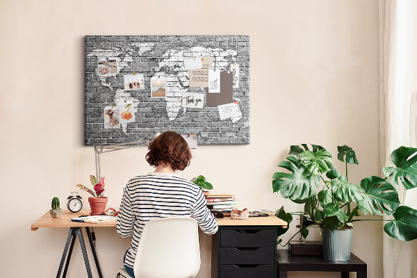 Korktafel mit Motiv Weltkarte an einer Backsteinmauer