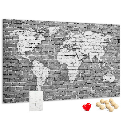 Korktafel mit Motiv Weltkarte an einer Backsteinmauer
