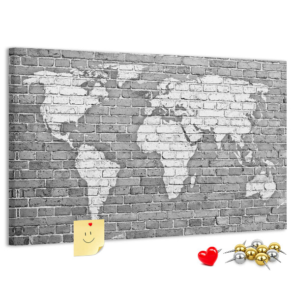Korktafel mit Motiv Weltkarte an einer Backsteinmauer